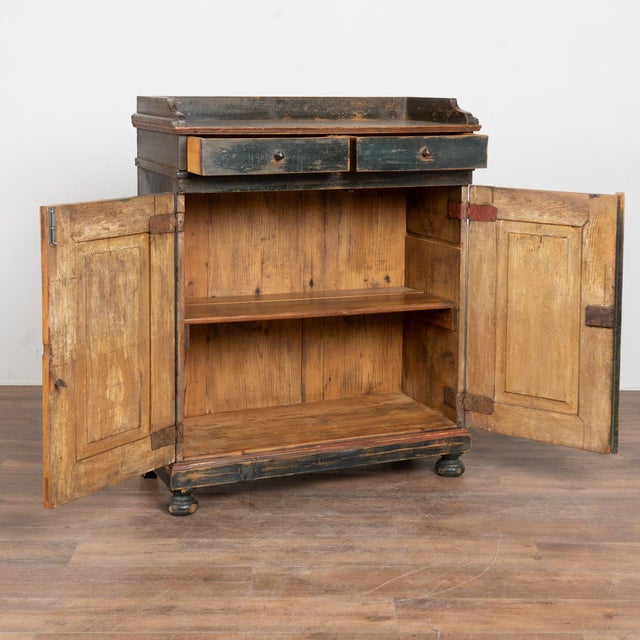 Early 19th-century Swedish pine cabinet sideboard retaining its original painted finish. The background presents both blue...
