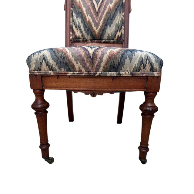 Charming, late 19th-century Victorian era side chairs crafted in warm walnut and (more recent) upholstered in a multi-...