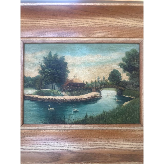 A charming early 20th century signed oil painting on board, depicting a peaceful river landscape with swans gliding across...