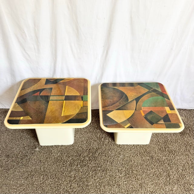 This striking pair of vintage Art Deco nesting tables features bold abstract epoxy tops layered with rich geometric forms...