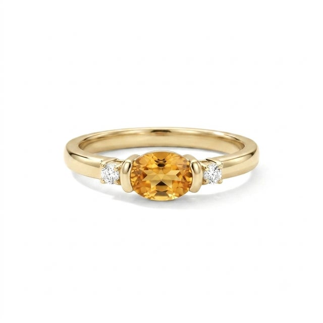 Sophisticated, contemporary, and beautifully minimalist. This exquisite three-stone ring features a stunning 6x4mm oval-...