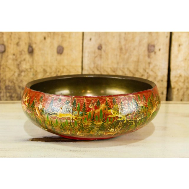A decorative hand-painted paper mache bowl finished with a brass lining. Its surface features a beautiful forest scene...