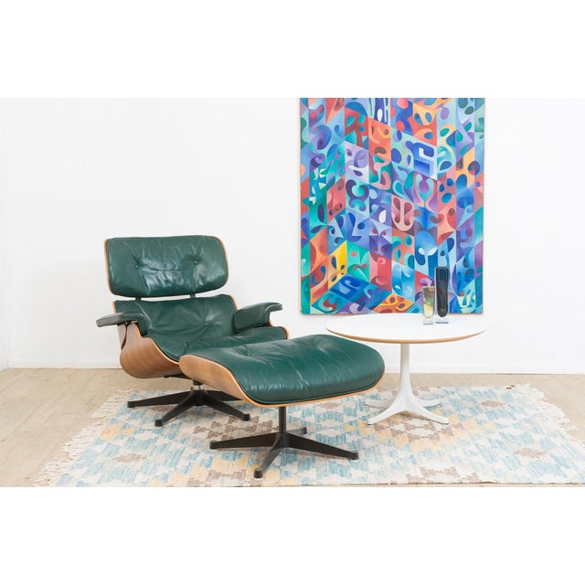 This original Herman Miller Eames Lounge Chair with matching ottoman combines avocado-green leather with expressively...