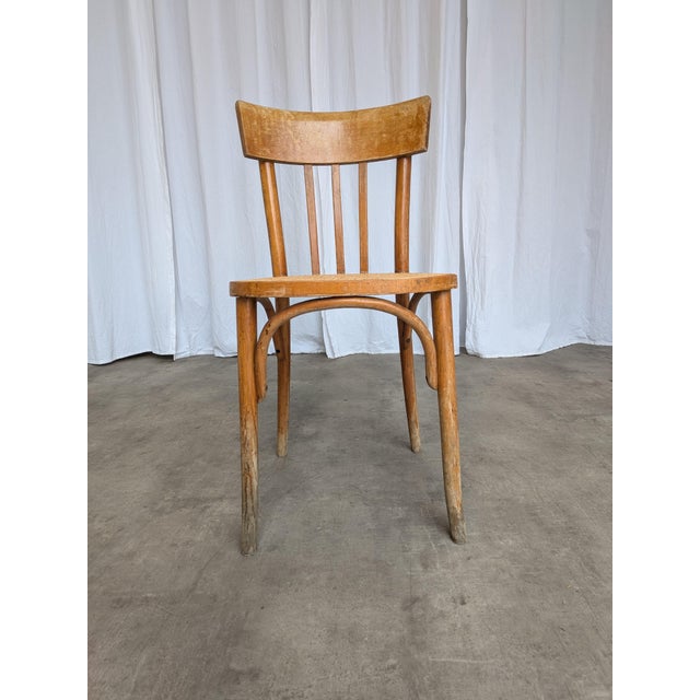Vintage bentwood dining chair made in the Thonet style around the mid-20th century. Crafted from bent beechwood using the...
