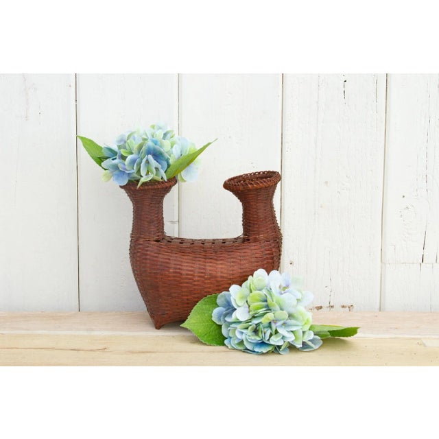 This antique woven basket from Thailand has a boat shape with a rounded body and two narrow neck openings. This old Thai...