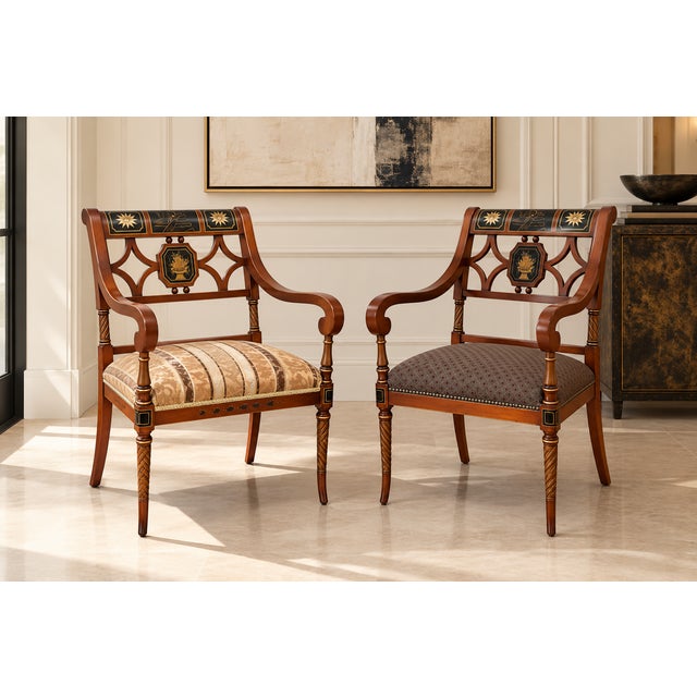 An elegant pair of Regency-style armchairs featuring beautifully shaped mahogany-toned frames with sweeping scroll arms,...