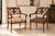 An elegant pair of Regency-style armchairs featuring beautifully shaped mahogany-toned frames with sweeping scroll arms,...