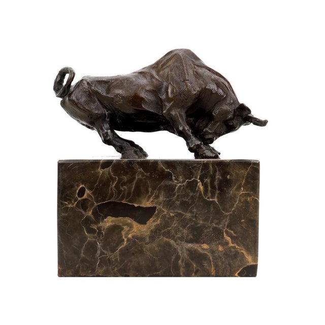 Art Deco style bronze bull figurine in brown patinated bronze, mounted on a dark rectangular marble base. This animal...