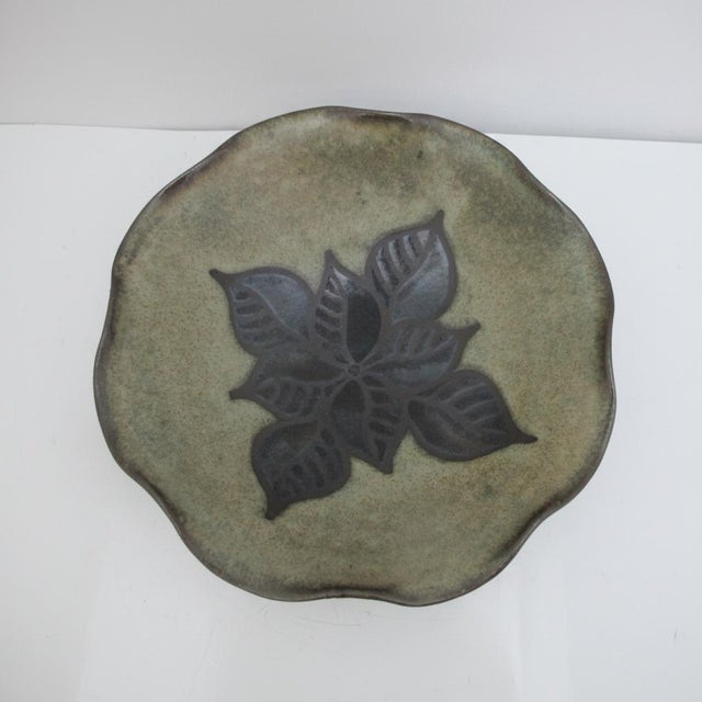Jane Woodside studio pottery bowl. Handmade ceramic bowl featuring a green and blue glaze with a central botanical motif....