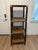 Vintage three-tier rattan and wood étagère featuring a dark finish, woven cane accents, and geometric wood-grain shelves....