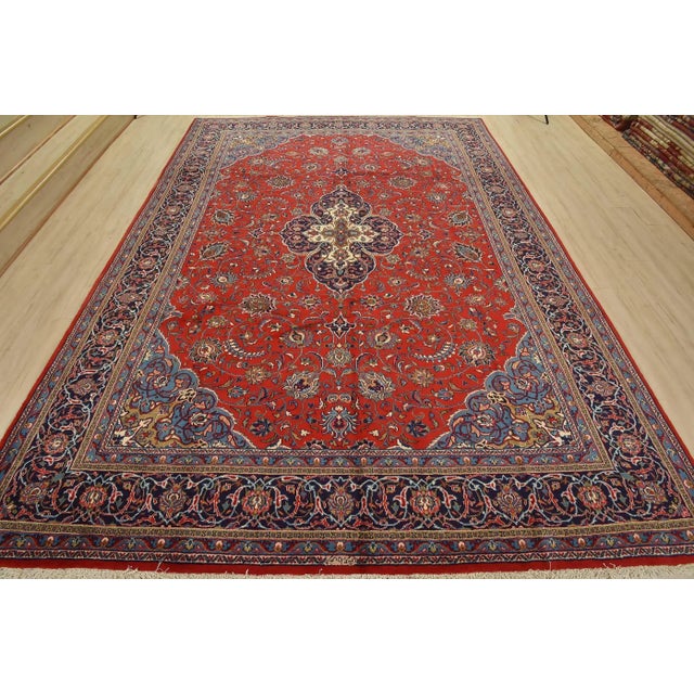 This authentic vintage traditional Sarouk rug is hand-knotted with an all-wool pile on a cotton foundation. This oriental...