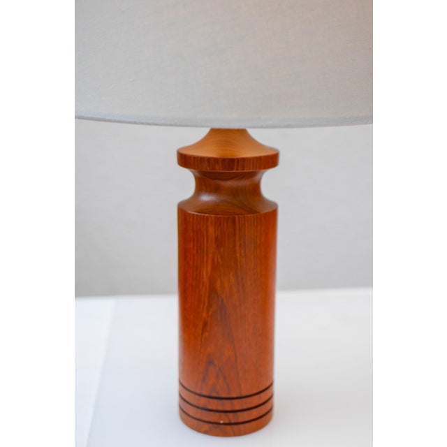 A rather large vintage Danish design teak table lamp from the 60s. A turned lamp with a classic shape, it has been turned...