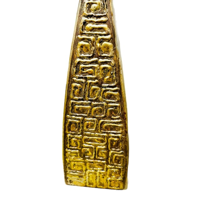 A 1950's Danish Brutalist brass table lamp with a triangular shape and repeating pattern. The lamp was crafted in brass...