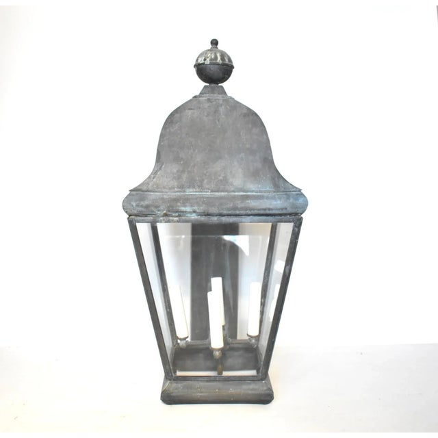 An antique, 19th-century galvanized tin metal outdoor lantern in the traditional carriage light shape, with a round finial...