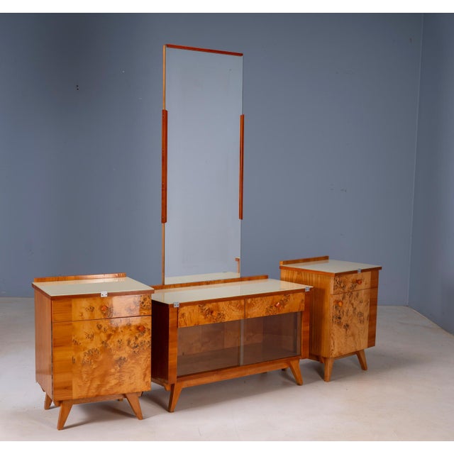 A distinctive mid-century dressing table from Czechoslovakia, featuring richly figured burl veneer, a large central...
