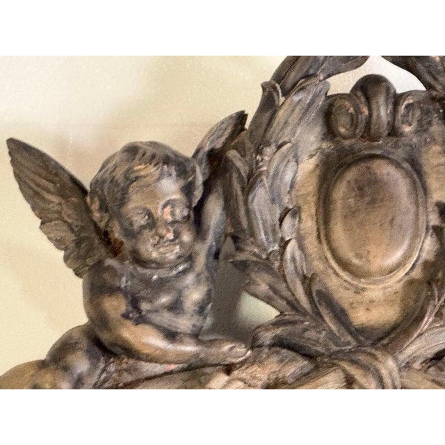 19th Century French Carved Wood Mirror with Cherub Crest A highly decorative 19th century French mirror featuring an...