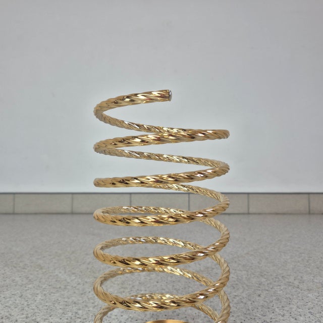Distinctive umbrella stand made of brass-plated metal, designed in the form of an elegant spiral resembling a spring....