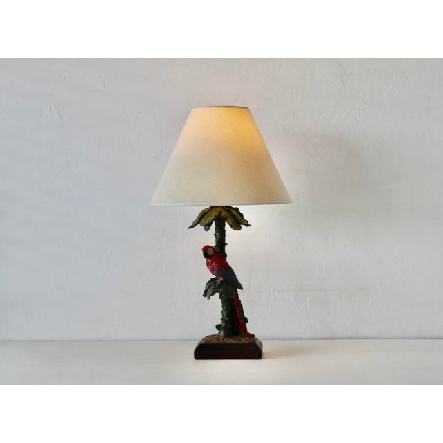 Vintage Majolica-inspired plaster hand-painted tropical table lamp featuring a red parrot perched on a palm tree-style...
