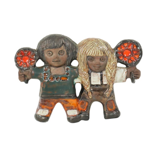 Vintage terracotta or earthenware wall sculpture, depicting two children, a boy and a girl, each holding a flower, art...