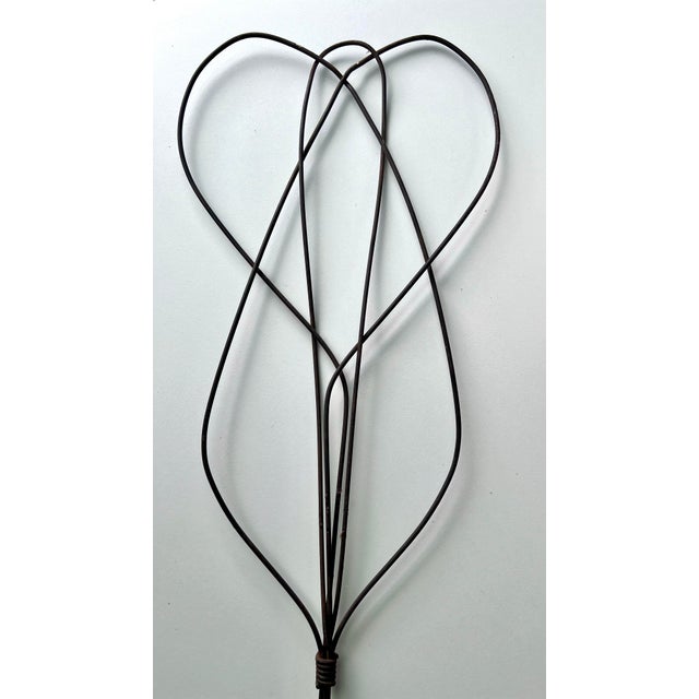 This is an antique rug beater. The carpet beater has a honey-comb twisted design with wooden handle with metal loop hang....