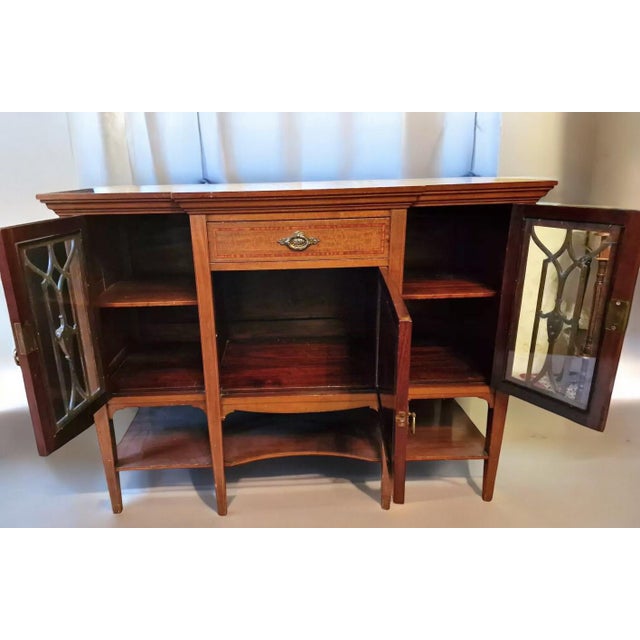 Antique English mahogany sideboard, elegant and refined, featuring a lovely glass-fronted front with period mullions. The...