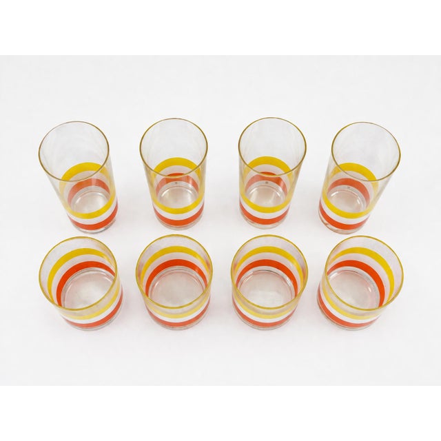This colorful set of 4 mid-century vintage striped "Collins" and 4 "Double Old Fashioned" or "Highball" glasses were...