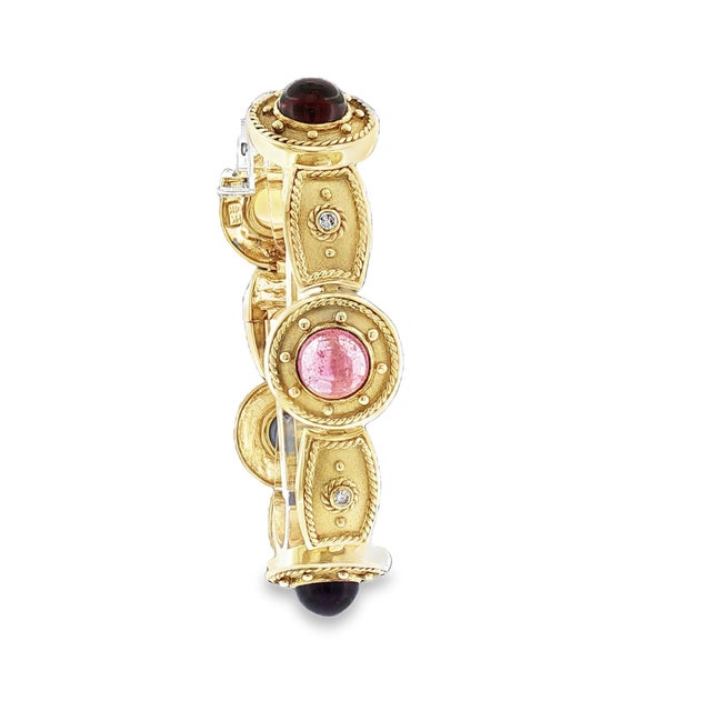 A link bracelet featuring a mix of gemstones set in 14k yellow gold. There are 5 brilliant-cut diamonds weighing 0.25...