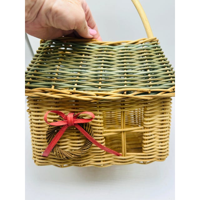 This is a delightful woven wicker basket designed in the shape of a little house — a whimsical and decorative piece. Form...