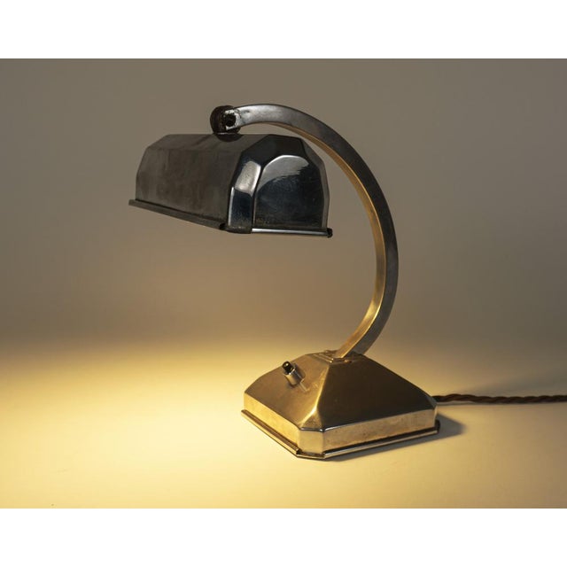 An original near-antique art deco bankers’ lamp in chrome-plated pressed brass, with adjustable neck and shade, and switch...