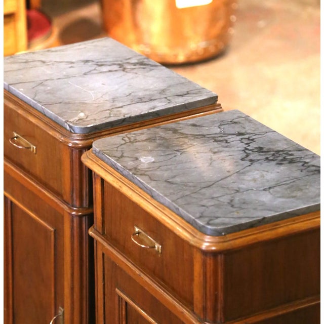Elegant and highly functional, this pair of antique bedside cabinets provides generous storage within a tall and narrow...