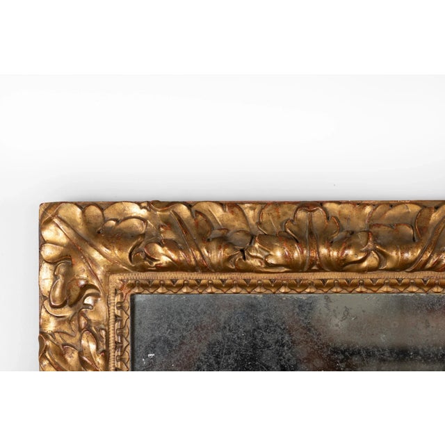 A French giltwood mirror frame, rectangular in form, featuring a carved foliate motif of acanthus leaves and scrolls. The...