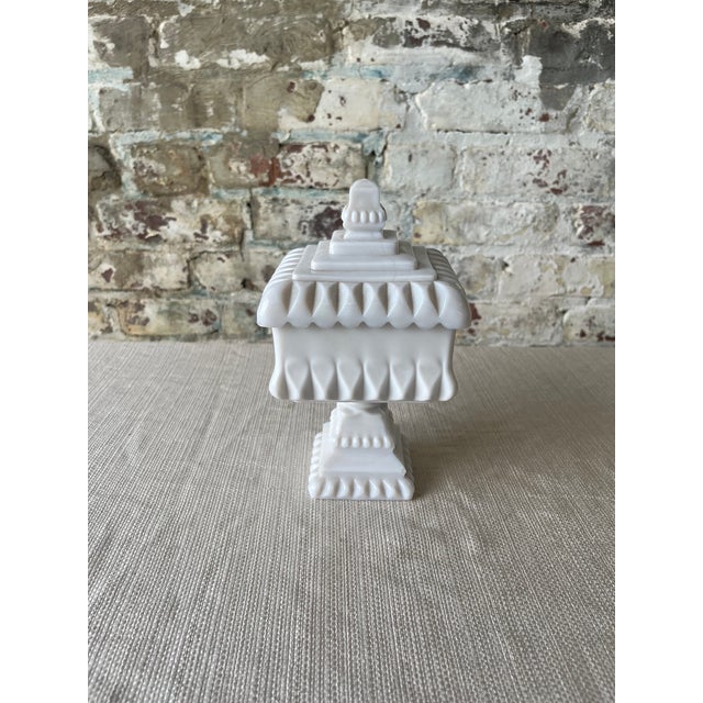 "This striking mid-century milk glass candy dish is a true sculptural gem. Featuring a square lidded bowl with teardrop...