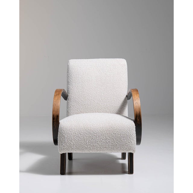 Upholstered armchair in Ivory Boucle. Its ivory boucle finish sets off curved wooden arms, gently tapered legs, soft ivory...