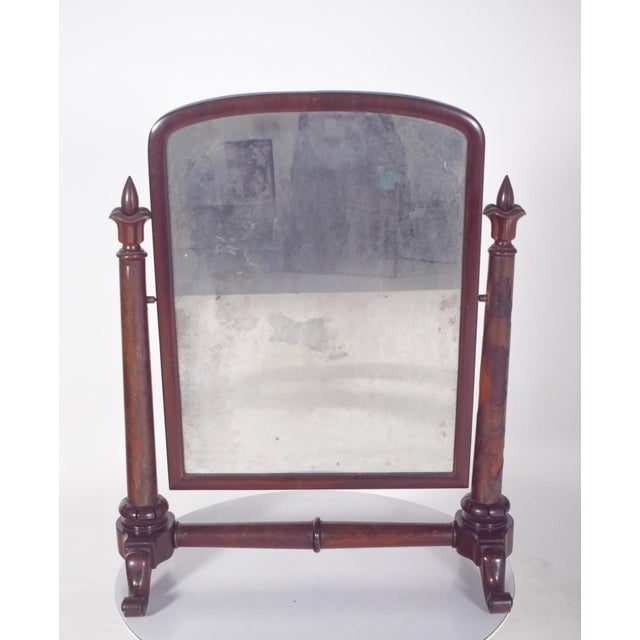 Dressing table mirror with turned edges. The mirror is rectangular, with rounded top corners and is set in a simple,...