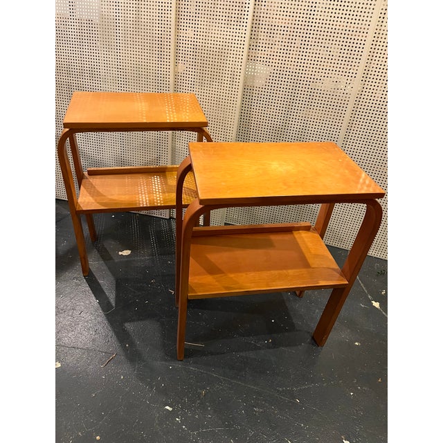 2 beautiful Mid-century wood side tables with curved lines and a lower shelf for books, plants or magazines. These little...
