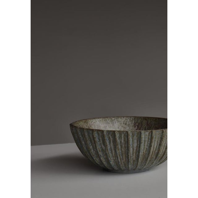 A classic stoneware bowl by renowned Danish ceramicist Arne Bang, model 189, showcasing his signature combination of...