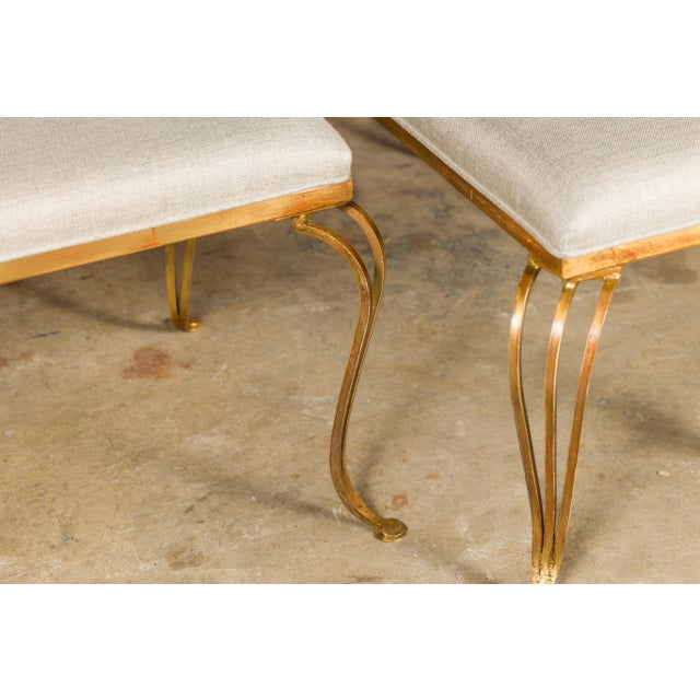 A pair of French gilt metal benches from the Midcentury period, with cabriole legs, pad feet and new custom linen...