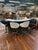 A dramatic Hollywood Regency bar ensemble featuring a sculptural serpentine white laminate top, dark wood veneer base, and...