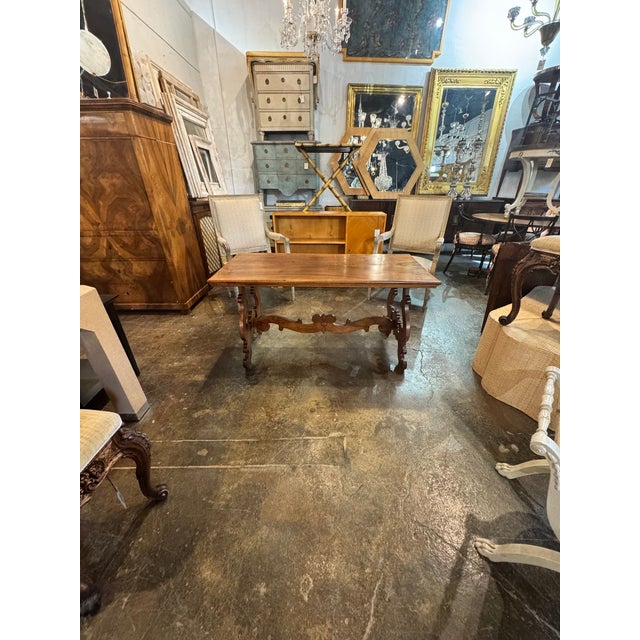 This 19th c. Italian Walnut Trestle Table is a classic piece of furniture. Featuring a curved details on the base and a...