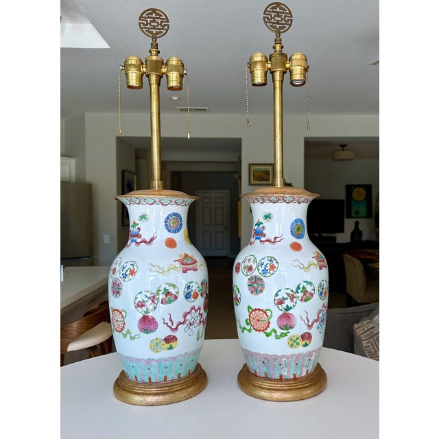 Pair of late 19th century Qing Chinese porcelain Famille Rose vases mounted as table lamps on gilt wood bases, made by the...