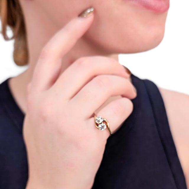 A fine antique gold and diamond cocktail ring. In 14 karat gold with a slight rose hue. With a pair of prong-set old mine...