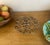 Christofle arabesque scrolling trivet set of three made in France in the 1960's. Small trivets 5.6" Large trivet 9.4"