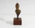 A signed miniature bronze sculpture. Signed to the back, the sculpture depicts the bust of a woman with her hair pulled...