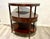 This vintage mahogany three-tier oval-shaped bar cart showcases classic design elements and functional versatility with...
