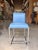 Contemporary counter stool featuring smooth sky blue genuine leather upholstery paired with a sleek stainless steel sled...