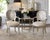 A glamorous pair of Hollywood Regency shell back armchairs featuring sculpted scallop-form backs, an antiqued silver leaf...