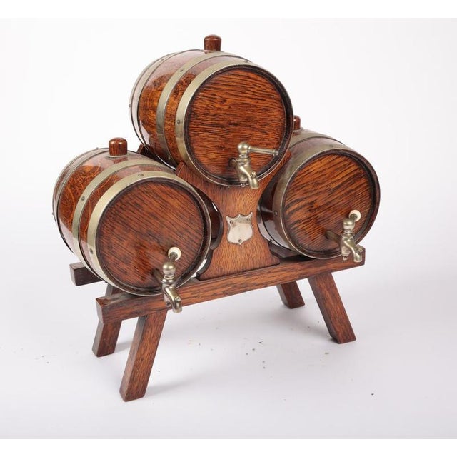 A rare, charming Edwardian Triple Liqueur Dispenser (c. 1900). Features three small oak barrels mounted on a trestle...