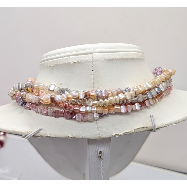 1981 goldtone multi-strand torsade resin faux-mother-of-pearl in shades of pink, purple, white, yellow and grey with bow...