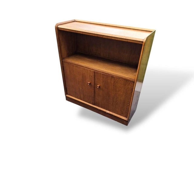 A beautifully proportioned vintage oak cabinet bookcase with a clean, understated mid-century feel. Featuring an open...