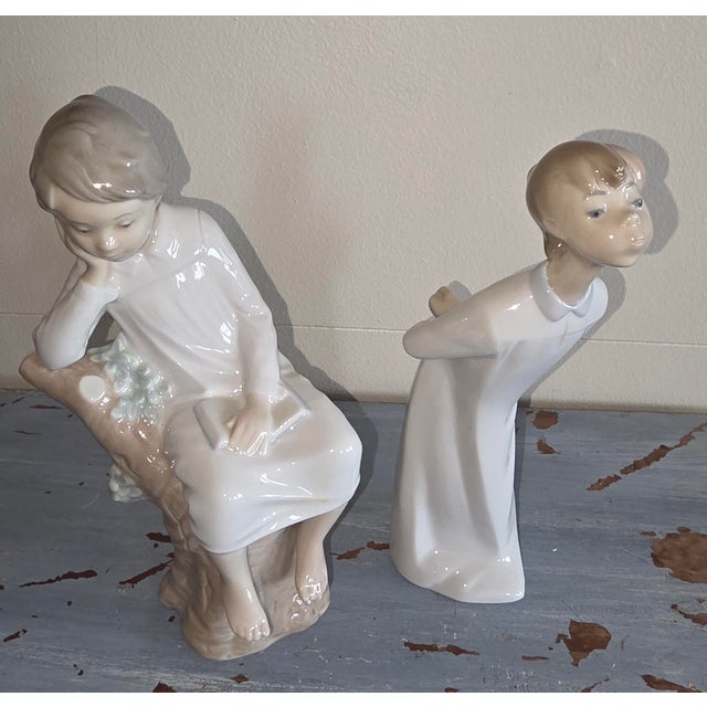 Classic Lladro figures....little boy thinking and little boy kissing. The little boy kissing is 7.75"h.